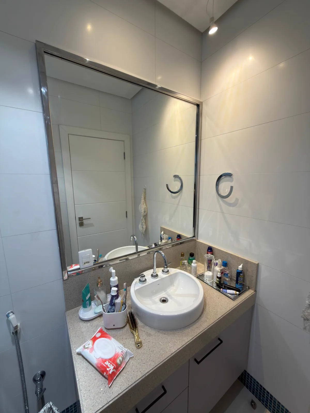 Moldura de espelho em inox polido sob medida instalada em banheiro residencial